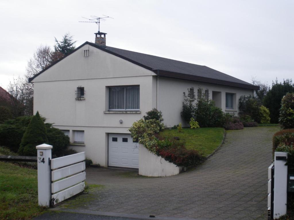 a white house with a driveway in front of it at Confort et Bien-être in Désertines