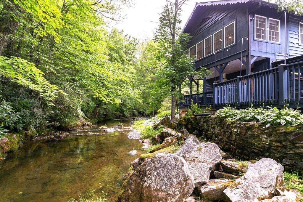 a house with a river in front of a building at Riverside Retreat in Boone