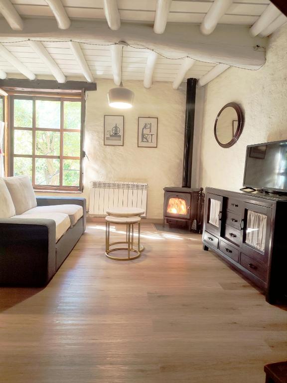 a living room with a couch and a fire place at La Herrera ll in San Esteban de la Sierra