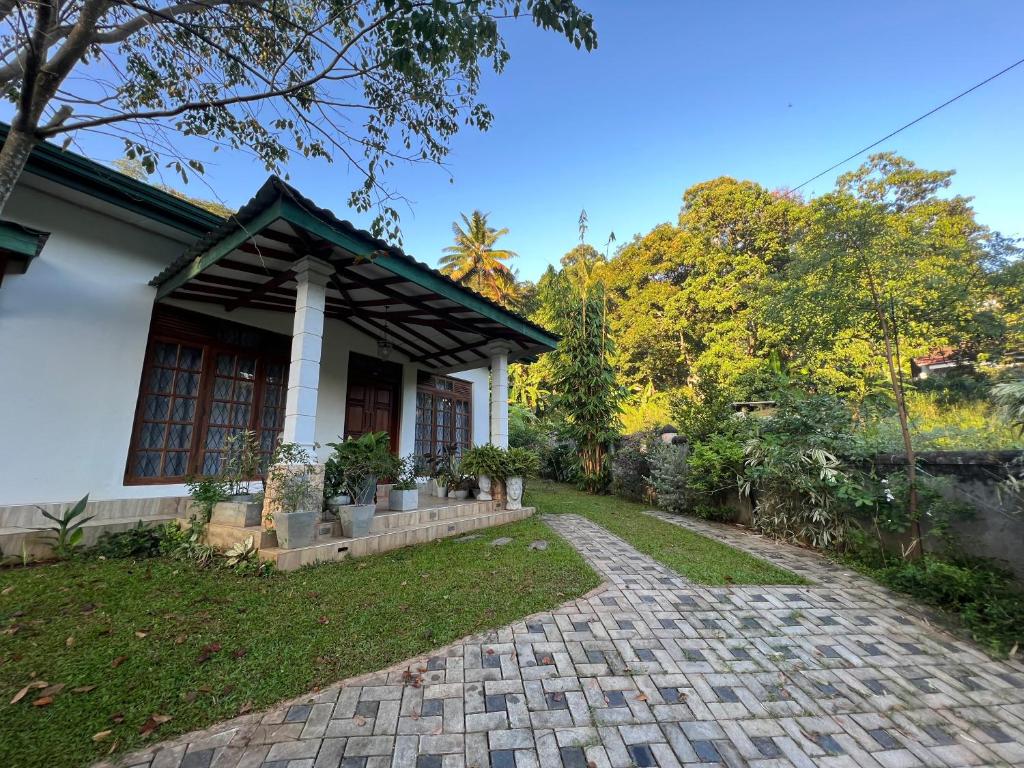 a house with a brick driveway in front of it at Serenique Greens in Peradeniya