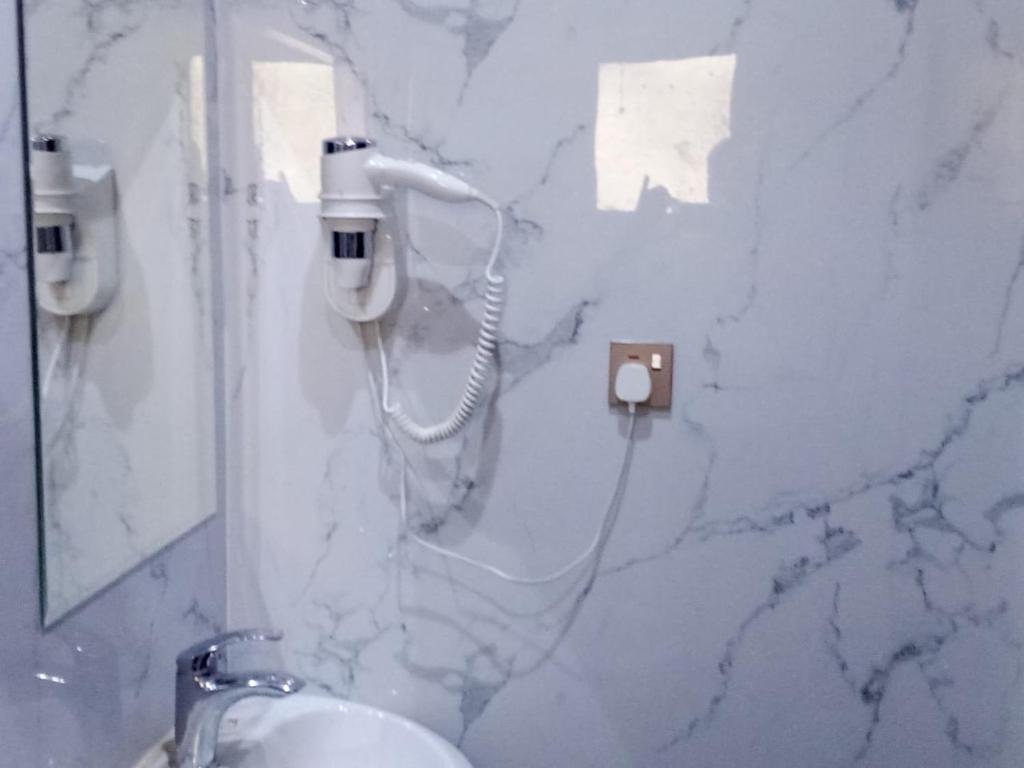 bagno in marmo con lavandino e specchio di اصيل الفاخره المخدومه a Taif