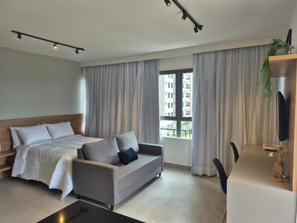 Un dormitorio con una cama y una silla y una ventana. en STÚDIO - Novo e Sofisticado!, en Princesa dʼOeste