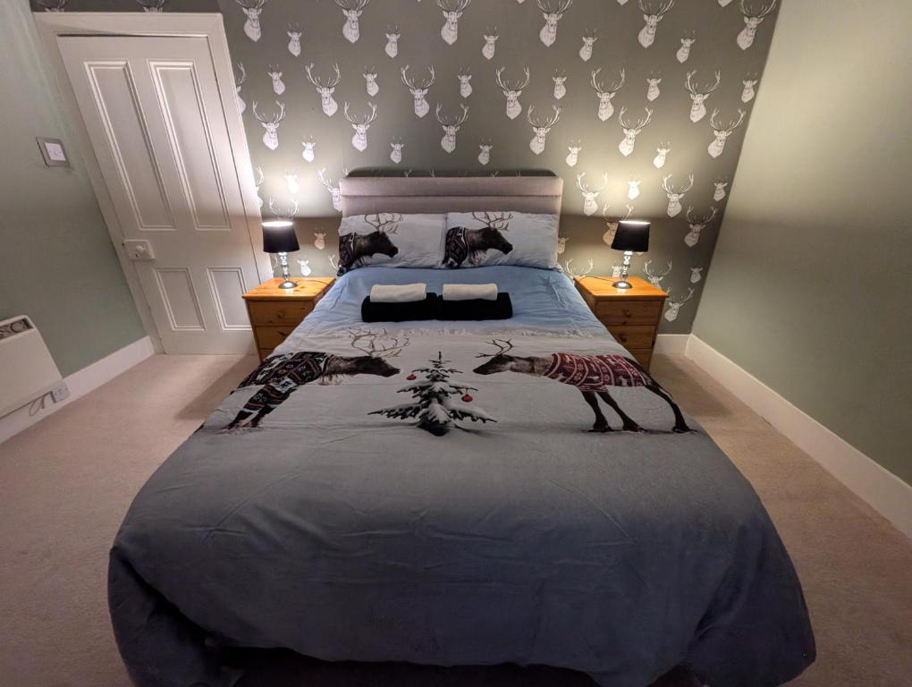 Foggiehoose based near Turriff Huntly Banff في Aberchirder: غرفة نوم عليها سرير وزرافتين