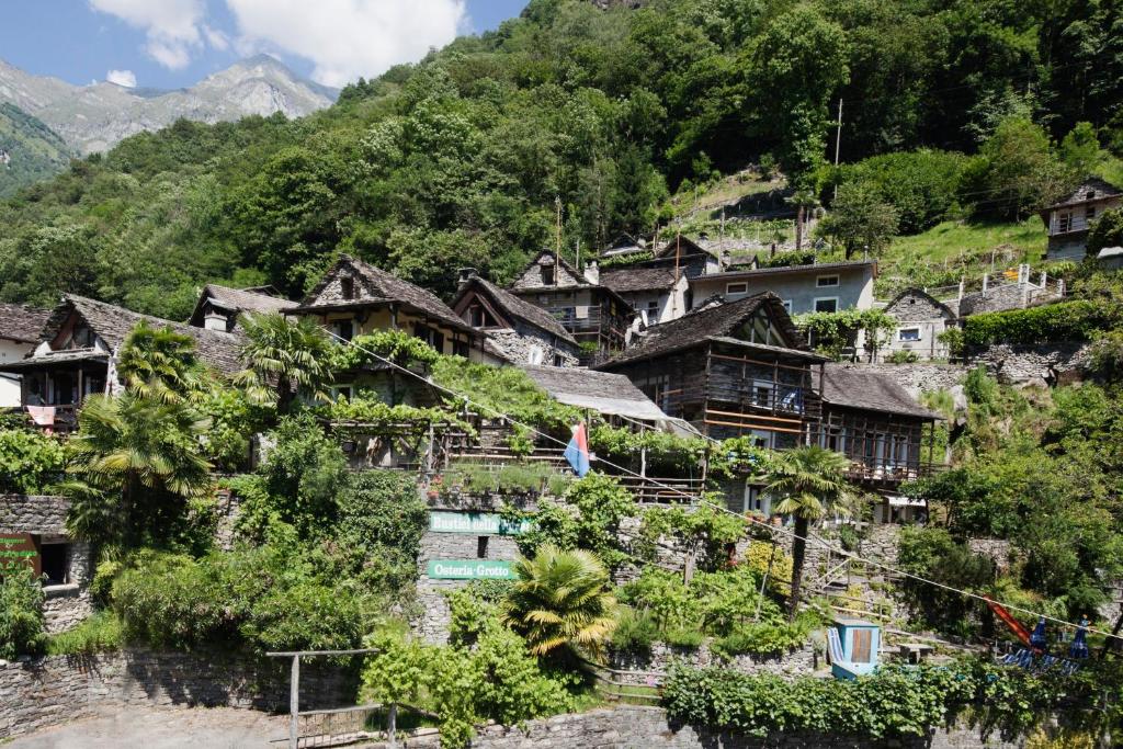 ein Dorf an der Seite eines Berges in der Unterkunft Rustici della Verzasca Ferien Wohnungen in Vogorno