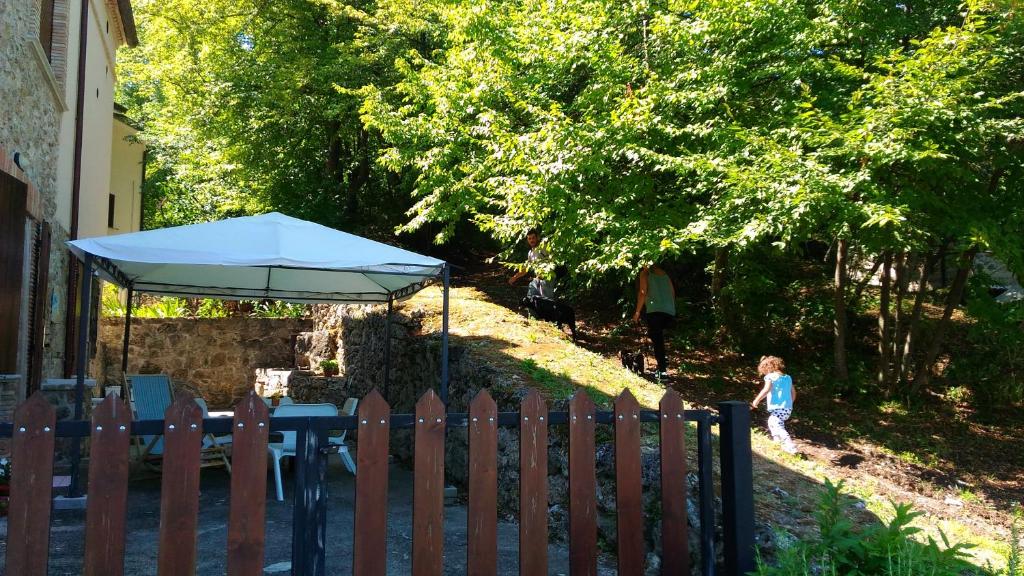 Roccamontepiano的住宿－皮特賴斯住宿加早餐旅館，一个小女孩用雨伞穿过围栏