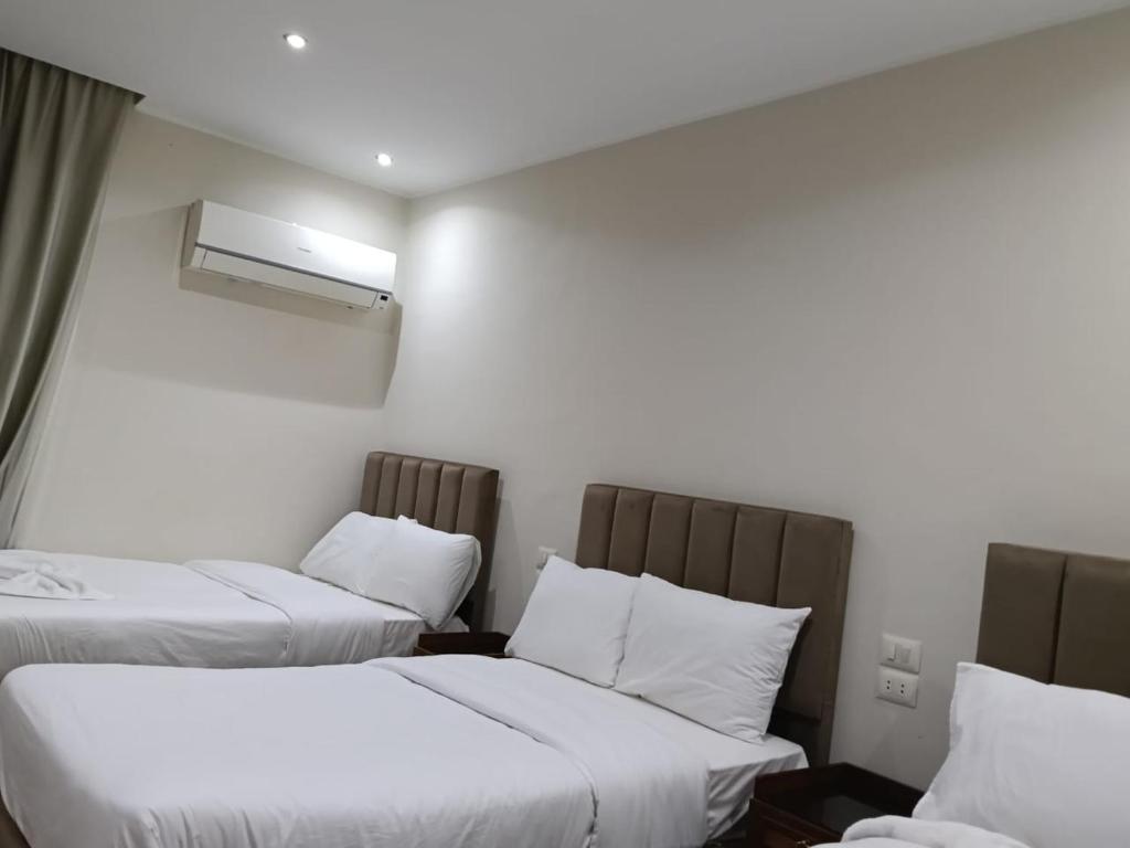 a hotel room with two beds and a window at Aurum Pyramids in Cairo
