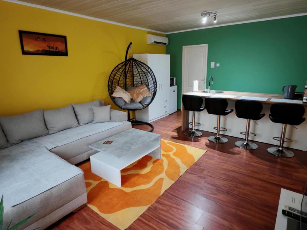a living room with a couch and a kitchen at City Apartman in Subotica