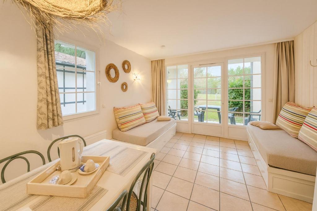 een woonkamer met een bank en een tafel bij Appartements au coeur du golf, proche du lac et vélodyssée in Biscarrosse