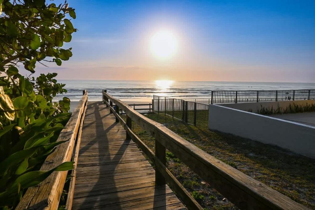 a boardwalk leading to the beach at sunset at Gorgeous Beach Front Condo Near Flagler Ave - 701 in New Smyrna Beach