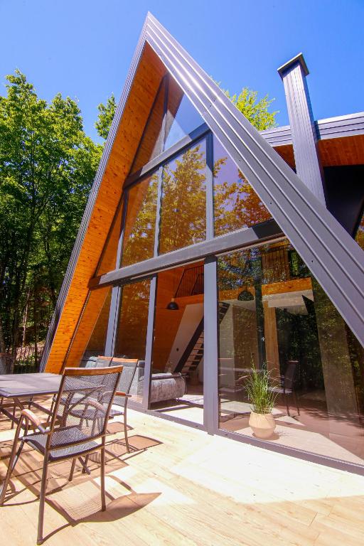 a glass house with two chairs and a table at Golf Forest Creek Villas in Zavidovići