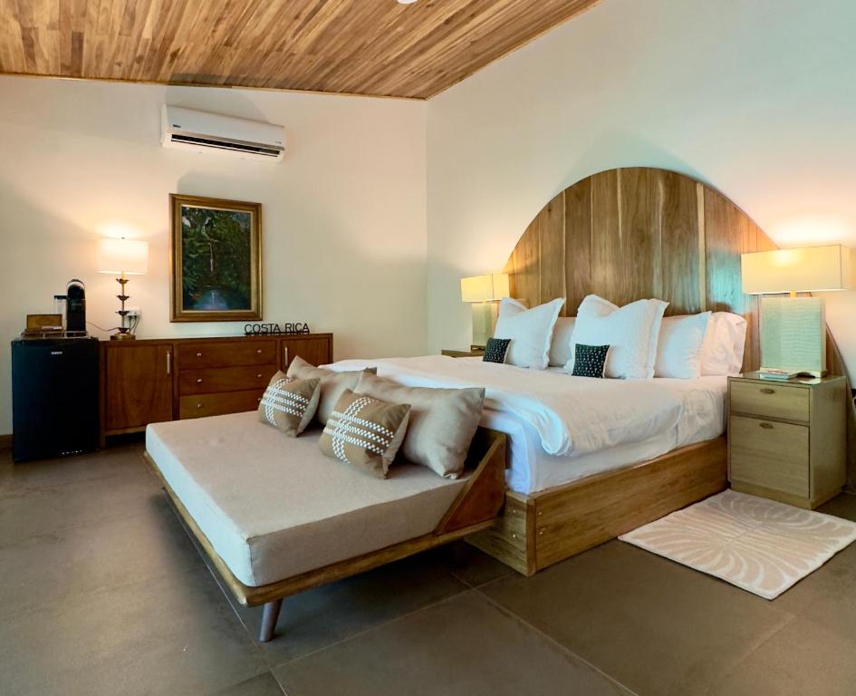 a bedroom with a large bed and a couch at Jungle Bungalow at Oropel Lodge in Puerto Viejo