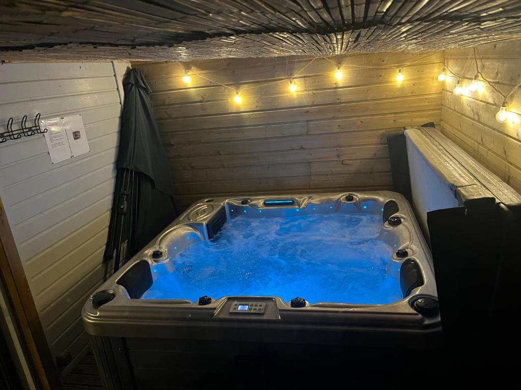 a large blue tub in a room with lights at Le petit Chalet in Port-Bail-sur-Mer
