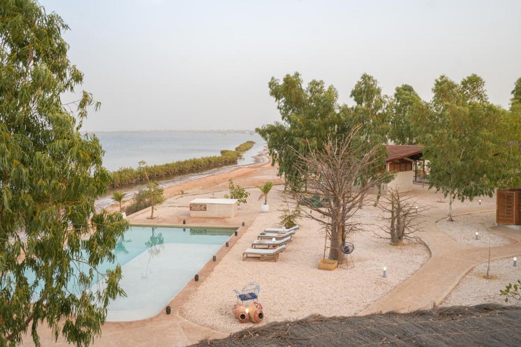an overhead view of a swimming pool with chairs and trees at Ecolodge Pout Pout in Fatick
