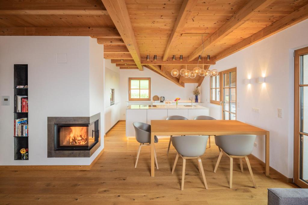 a kitchen and dining room with a table and a fireplace at Tagenhof Mountain Living in Meluno