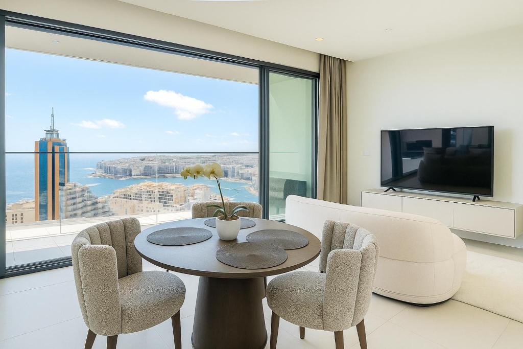 a living room with a table and chairs and a large window at IsLe Mercury Tower By DIoOR in St Julian's