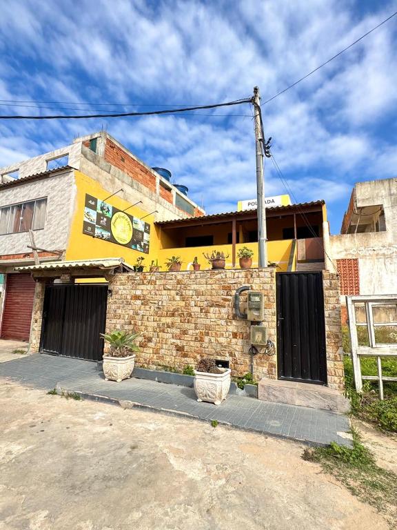 a brick building with a clock on the side of it at Pousada Recanto de Figueira in Arraial do Cabo