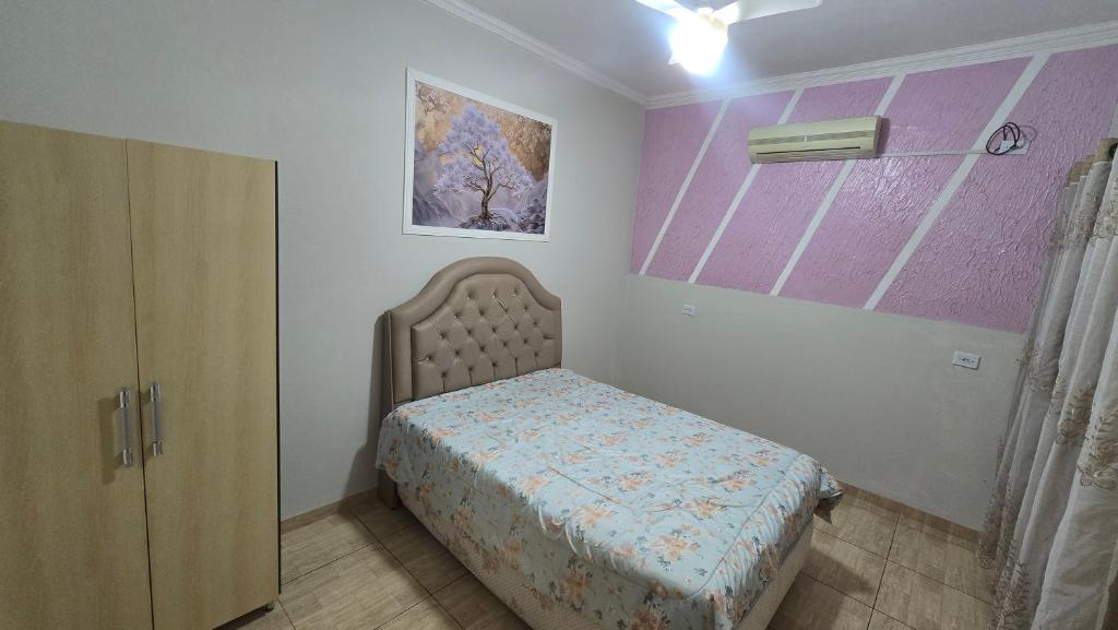 a small bedroom with a bed and a cabinet at Casa aconchegante 4 minutos do thermas in Andradina