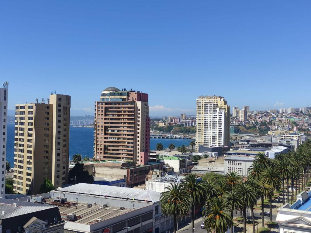 a city skyline with tall buildings and palm trees at Vista Mar Loft Apartment Downtown Valparaíso in Valparaíso