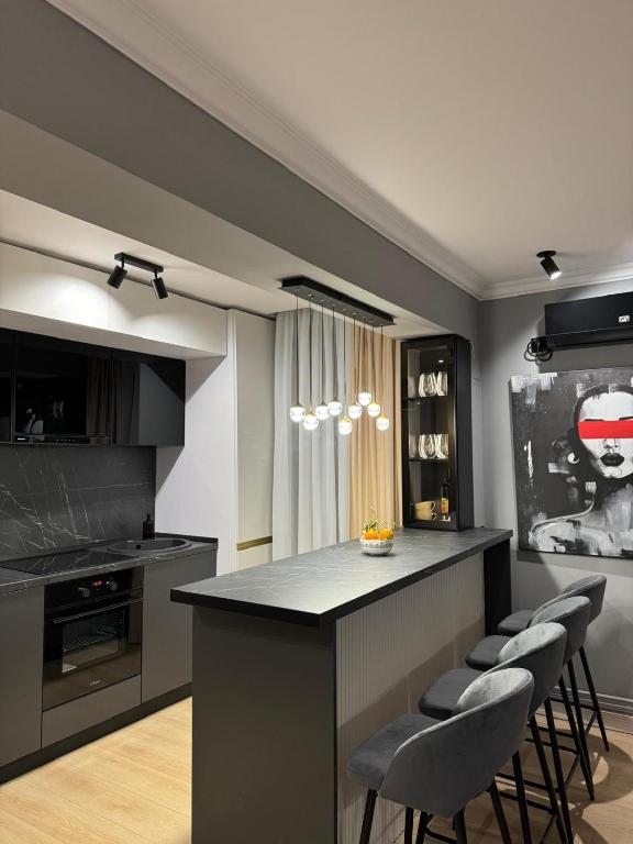 a kitchen with a counter and stools in a room at Cuza Residence in Craiova