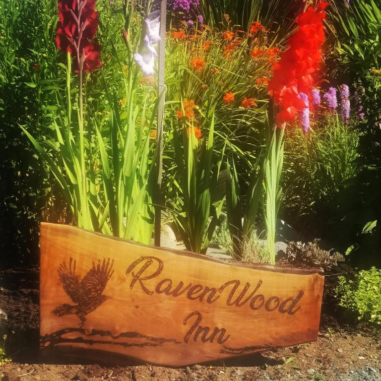 a sign in front of a bunch of flowers at Saratoga beach cabin with hot tub in Oyster Bay