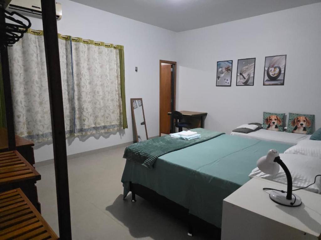 ein Schlafzimmer mit einem Bett und einem Schreibtisch mit einer Lampe in der Unterkunft Jardim Primavera in Palmas