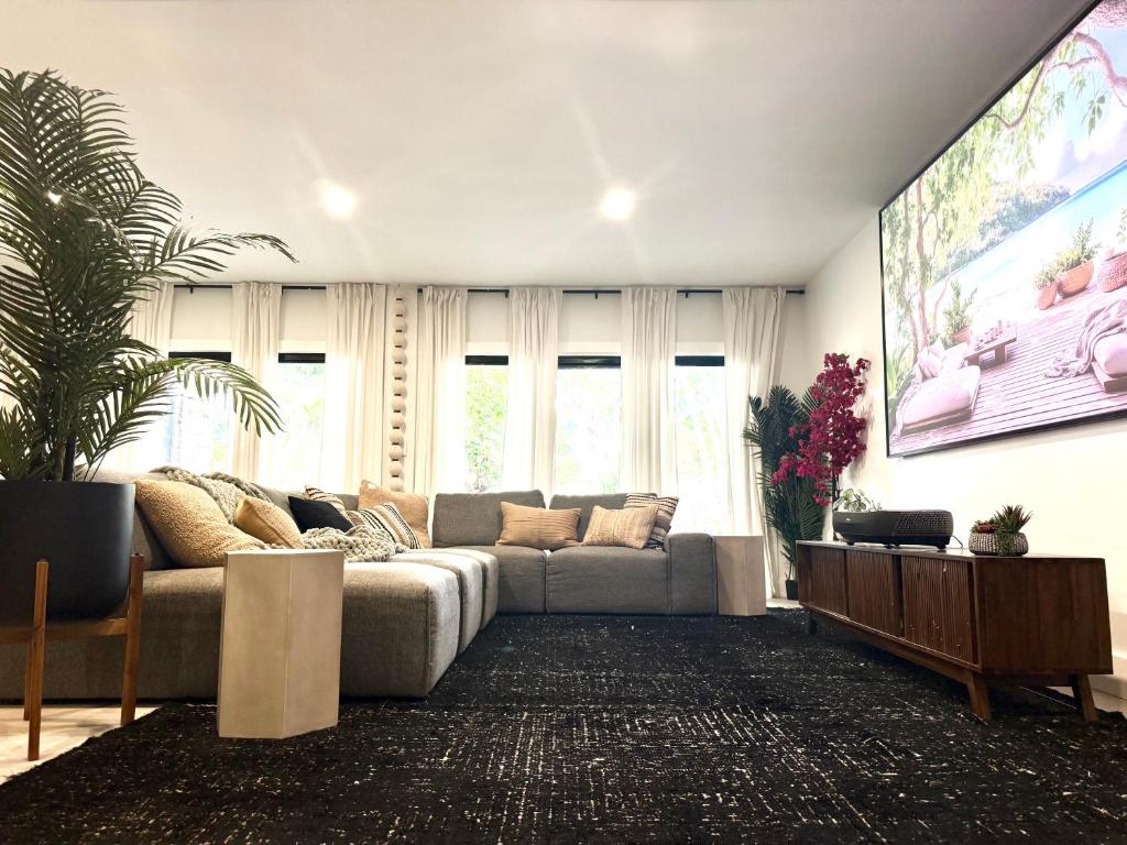 ein Wohnzimmer mit einem Sofa und einem großen Bildschirm in der Unterkunft Tabu- Fort Lauderdale Waterfront Escape in Fort Lauderdale
