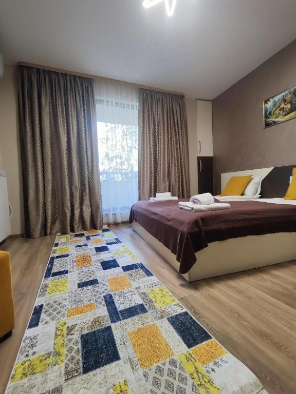a bedroom with a bed and a large window at Madini apartment in Velingrad