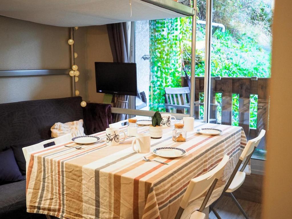 a table with a yellow and white striped table cloth at Studio cosy proche départ station de ski in Porté-Puymorens