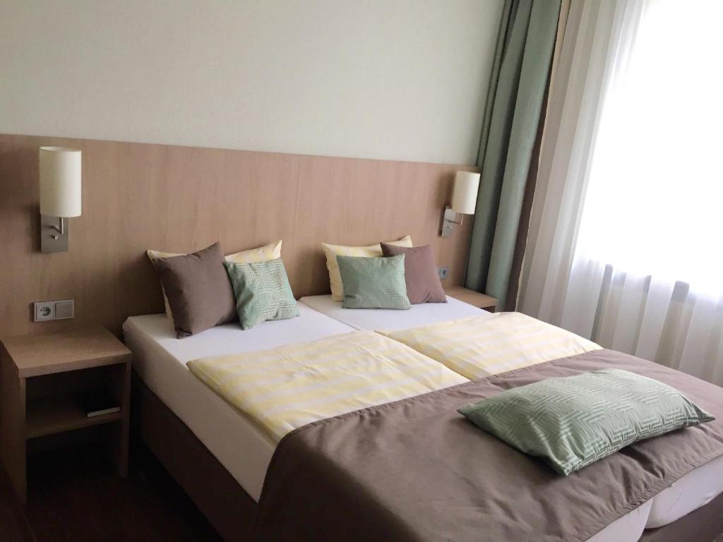 ein Schlafzimmer mit einem großen Bett mit Kissen darauf in der Unterkunft Hotel Concordia in Euskirchen