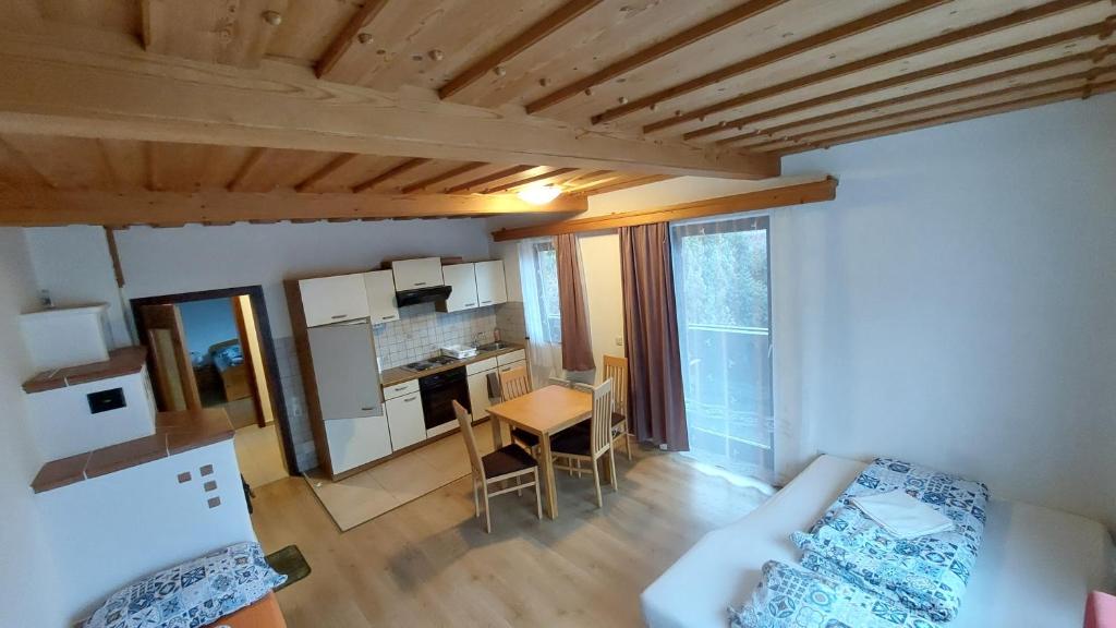 a room with a bed and a table and a kitchen at Sissi Apartment in Ausserfragant