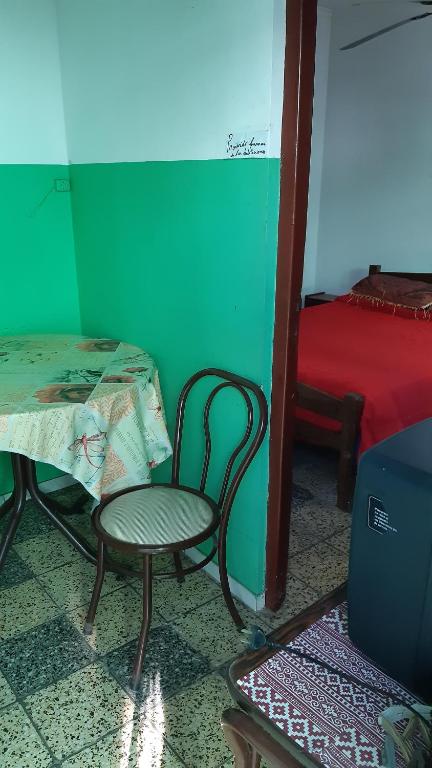 a room with a table and a chair and a bed at Sil-Cris-Mar in Carhué