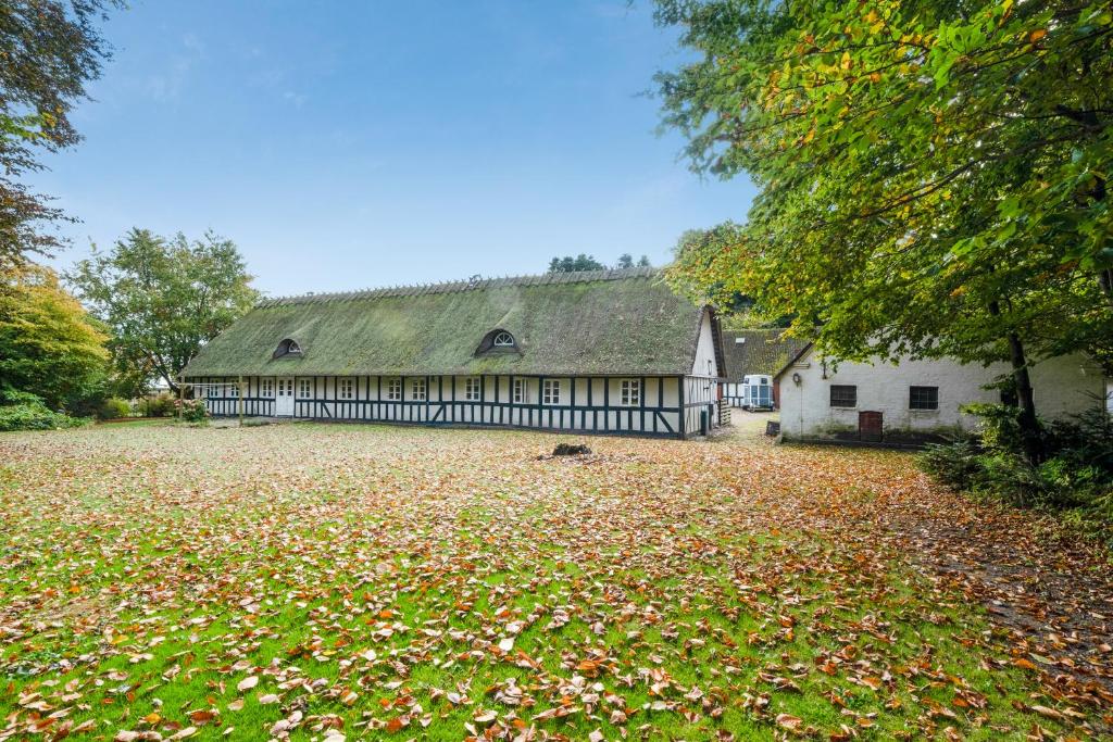 a large house with a large yard with leaves on the ground at Annexgården 9A in Tommerup