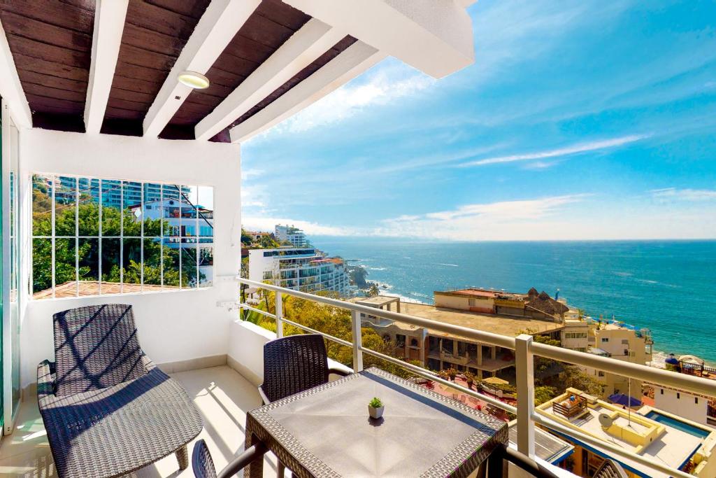 een balkon met een tafel en stoelen en de oceaan bij Torre Malibu, PH # 901 in Puerto Vallarta
