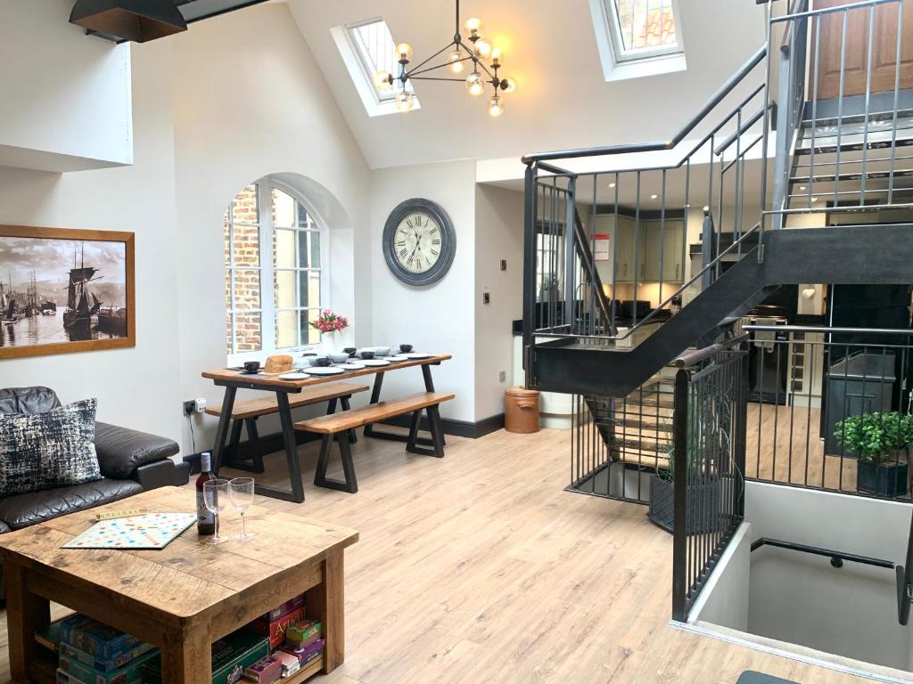 a living room with a spiral staircase and a table at The Old Bakery - Luxury Three Bed House with Roof Terrace in Whitby