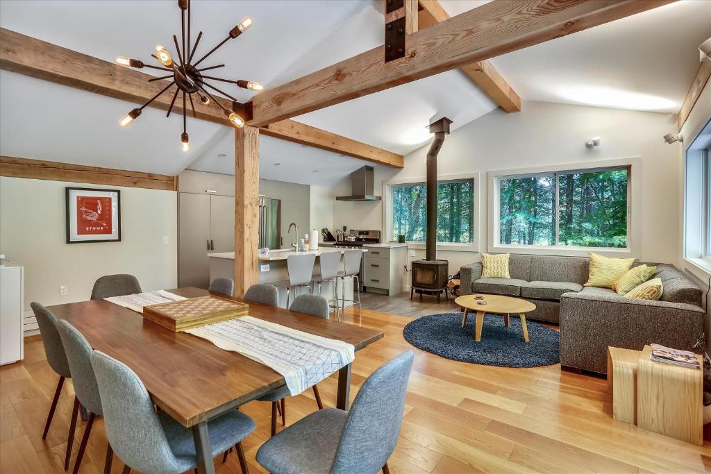 a dining room and living room with a table and chairs at Tollhouse 10C: 3 br, ski-in/ski-out, woodstove, free ski shuttle, a/c, summer pool in Stowe