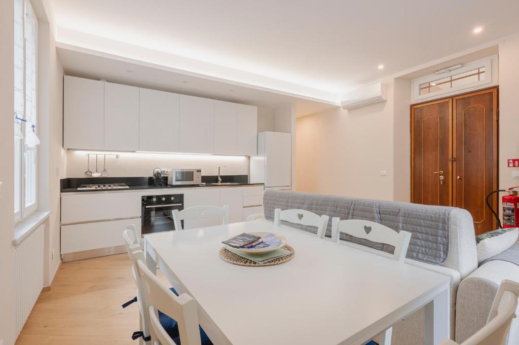a kitchen and living room with a white table and chairs at La Casa di Biancaneve in Recco