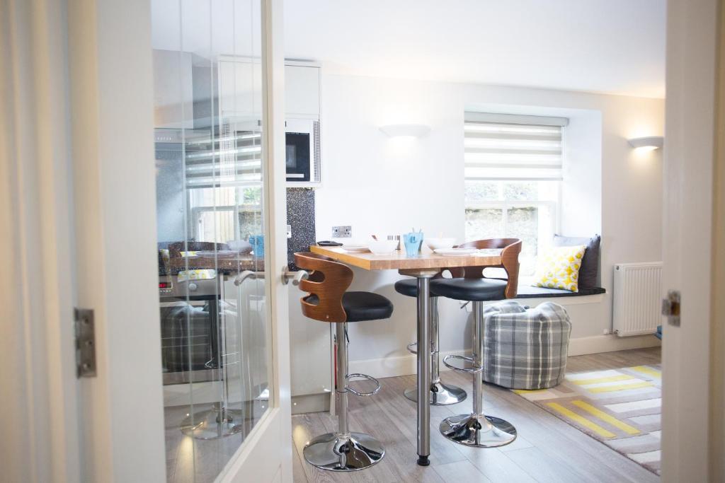 a kitchen with a table and two bar stools at Glenmoriston Town House Apartments in Inverness