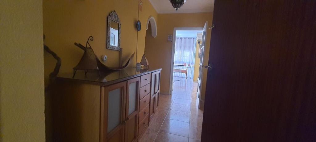 a kitchen with a dresser and a mirror on the wall at Rooms Tourist Apartment in Huelva
