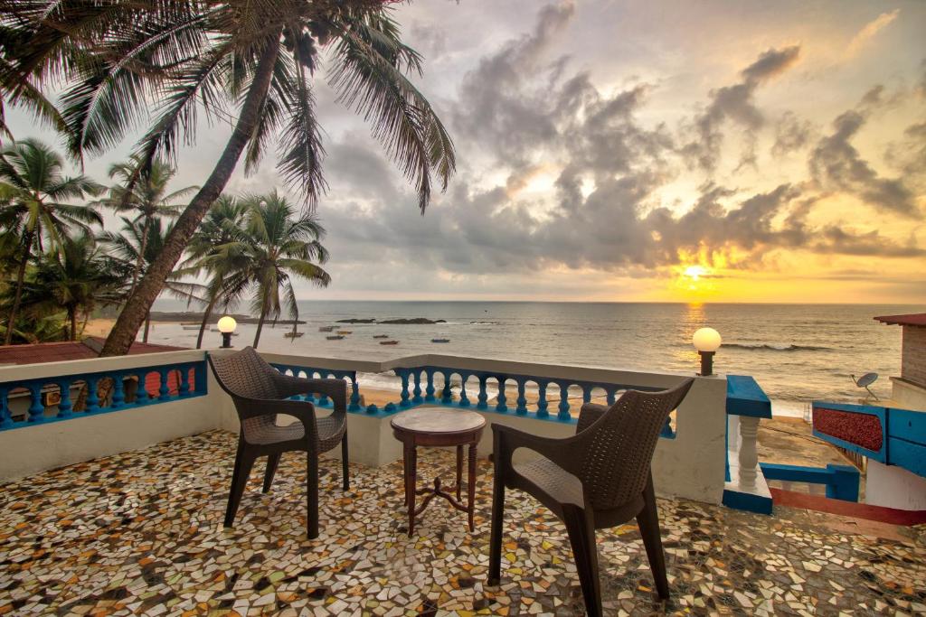 a table and chairs on a balcony overlooking the ocean at Anjuna House With Ocean View in Anjuna