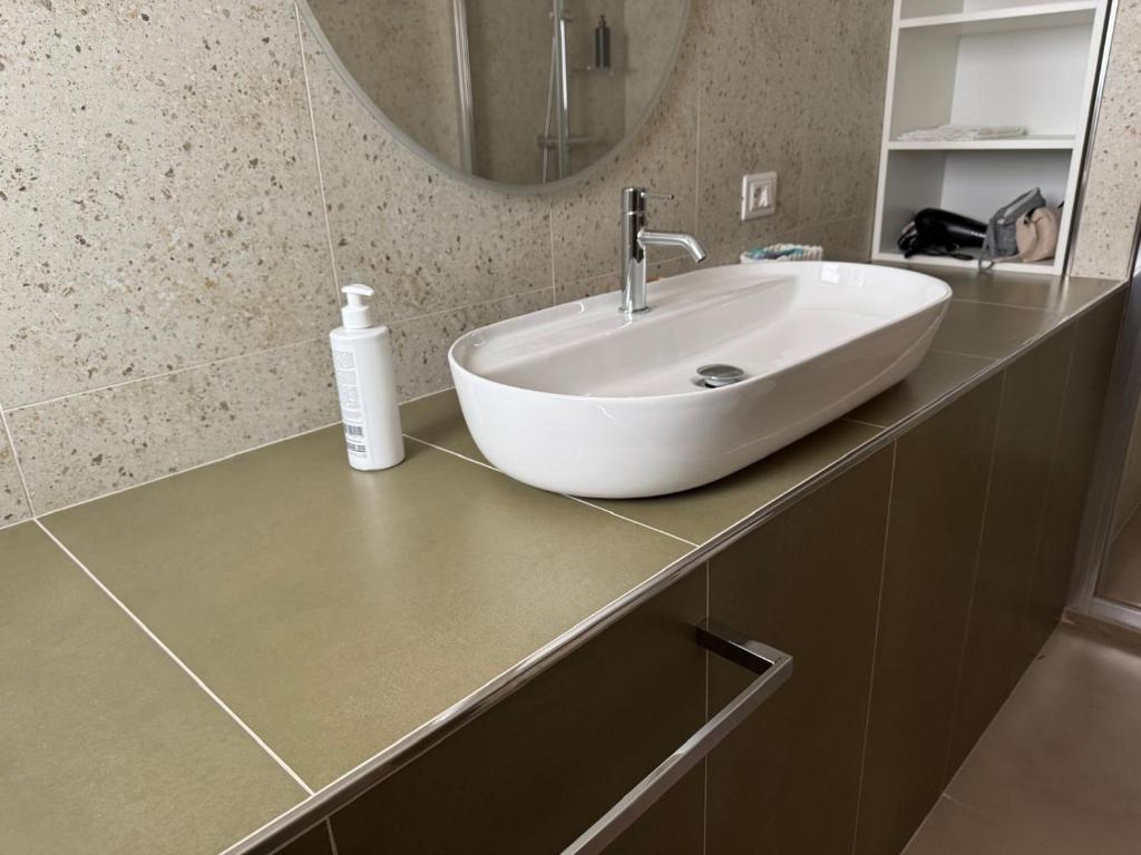 een badkamer met een witte wastafel en een spiegel bij Casa e Cori in Acireale