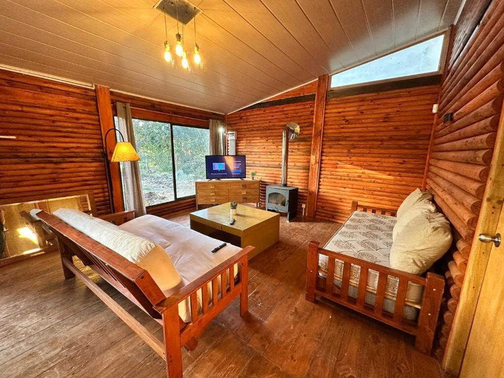 a room with two beds in a log cabin at Macondo in Sauce de Portezuelo