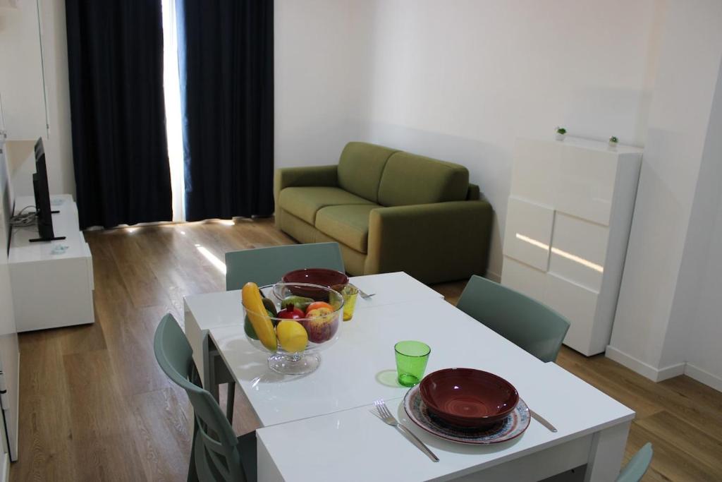 a living room with a table with a bowl of fruit on it at Flamingo Houses in Quartu Sant'Elena