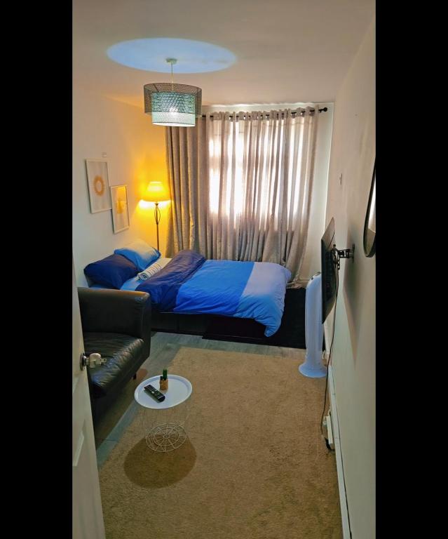 Un dormitorio pequeño con una cama y un sofá. en YouShelter, en Londres