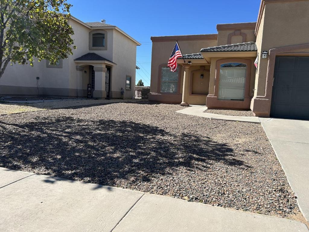 une maison arborant un drapeau américain dans une allée dans l'établissement La Casa Luna, à El Paso