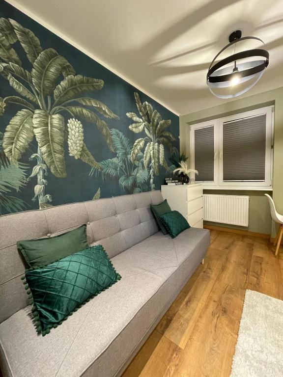 a living room with a couch and a wall mural at Chill Apartament Gdynia in Gdynia