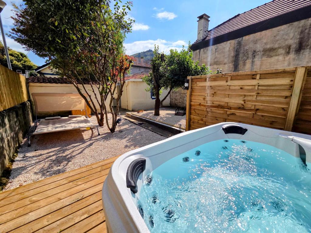 a jacuzzi tub sitting on a wooden deck at L'Ombre du Hêtre in Lourdes
