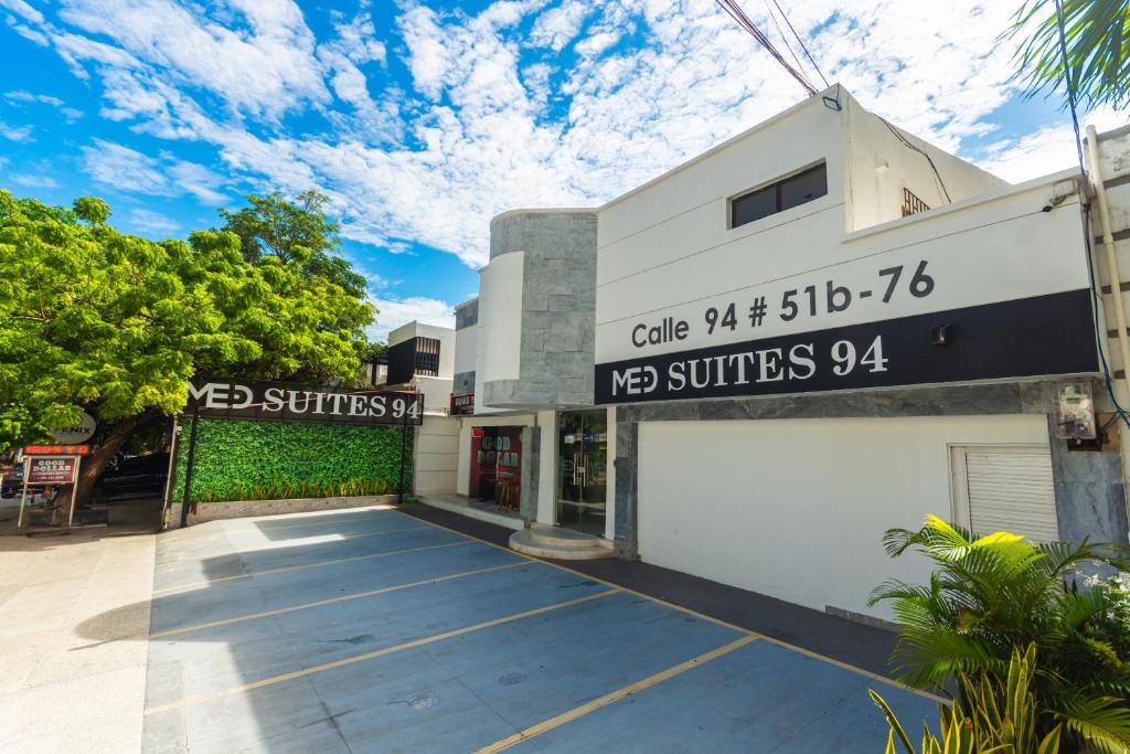 un bâtiment avec un parking devant dans l'établissement Hotel Med Suites 94, à Barranquilla