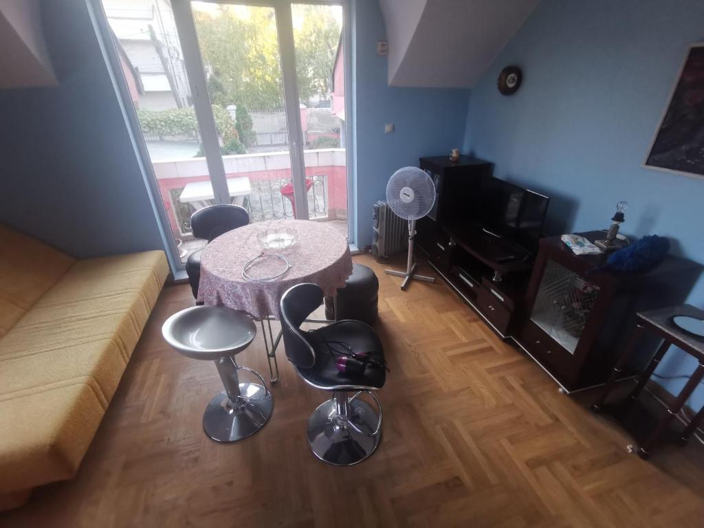 Una sala de estar con una mesa y sillas y un sofá. en Kraljevacka 13, en Belgrado