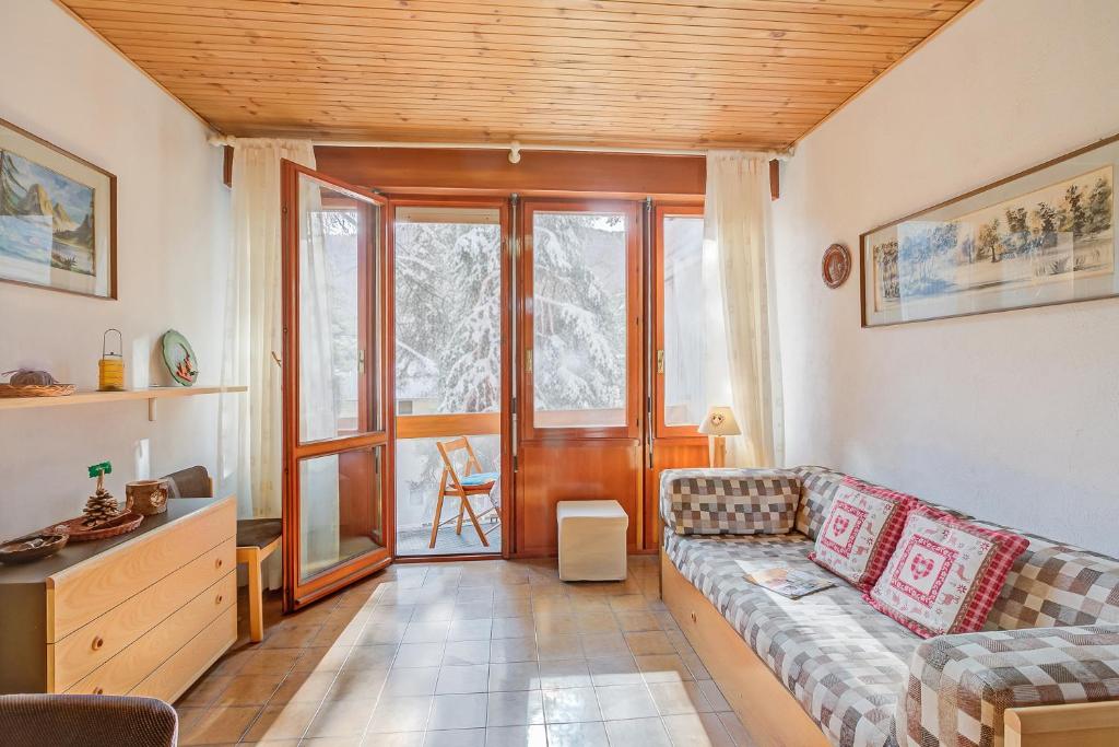 Una sala de estar con un sofá y una ventana. en Slalom 73 - Happy Rentals, en Bardonecchia