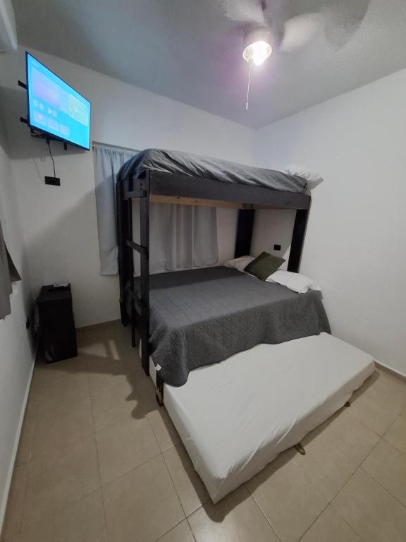 a bedroom with a bed and a flat screen tv at DGM Lofts GPE 3 Parque Fundidora in Monterrey